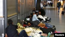 Para migran tidur di lorong kereta api utama di Munich, Jerman (13/9). (Reuters/Michaela Rehle)