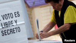 A voter casts a ballot during the election of 60 deputies, to form the Constituent Assembly that will create a constitution for Mexico City, in Mexico City, June 5, 2016. 