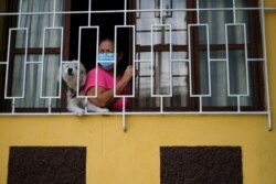 Un residente observa a los trabajadores sanitarios del municipio yendo de casa en casa, mientras realizan un seguimiento de contactos en medio de la pandemia, en Soyapango, El Salvador, el 3 de julio de 2020.