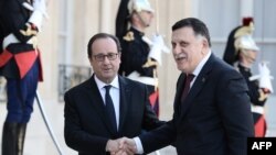 French President Francois Hollande (L) welcomes Prime Minister of Libya's Government of National Accord, Fayez al-Sarraj, upon his arrival at the Elysee Palace in Paris, Sept. 27, 2016.