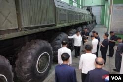 8일 국방공업기업소를 방문한 김정은 북한 국무위원장 뒤로 이동식발사대(TEL)의 모습이 보인다. (사진출처: 조선중앙통신)