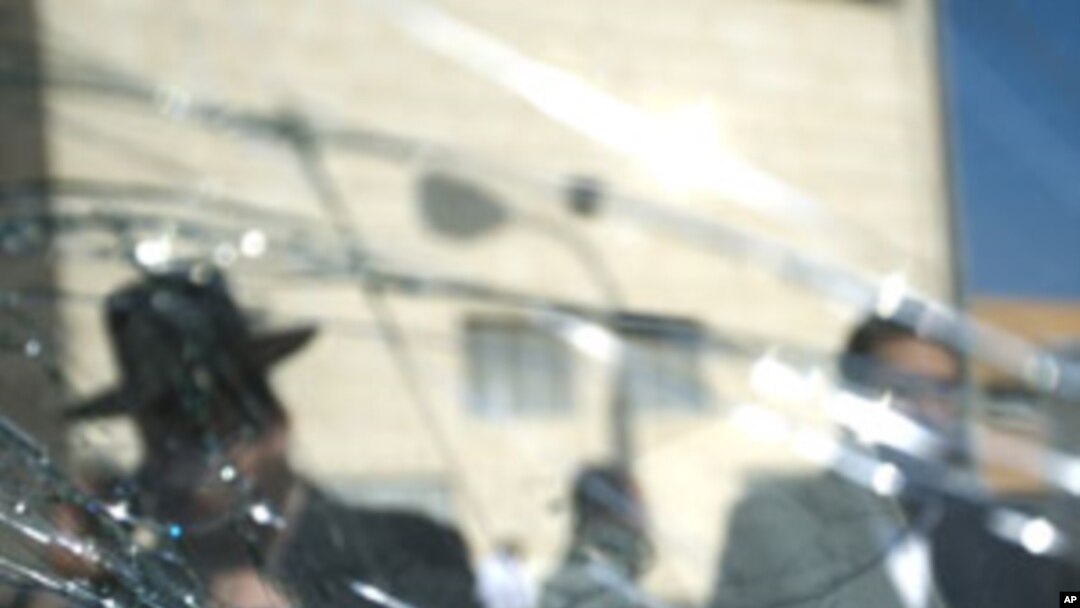 Orthodox Jewish men are seen through a shattered window near a synagogue after a rocket was fired by Palestinians militants from Gaza Strip hit Ashdod, Israel, August 19, 2011