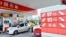 A price board with arrows indicating falling fuel prices is seen as an employee fills the tank of a car at a PetroChina gas station in Hangzhou, Zhejiang province, China, March 26, 2013.