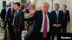 唐纳德·特朗普总统在白宫的国宴厅向全美大学体育协会(NCAA)全国冠军队发表讲话后，在离场时向众人挥手致意。(2026年4月21日)