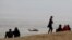 People look on as an Israeli rescue helicopter operates near the site where a group of Israeli youths was swept away by a flash flood, near the Zafit river bed, south of the Dead Sea, Israel, April 26, 2018. 
