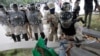 A Haitian National Police (PNH) officer pushes a protestor during clashes at a demonstration demanding the resignation of Haiti's President Jovenel Moise, at the 217th anniversary of the Battle of Vertieres, the last major battle of Haitian independence.