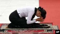 Burmese opposition leader Aung San Suu Kyi pays respect at tomb of her late father, Gen. Aung San, in Rangoon, July 19, 2012.