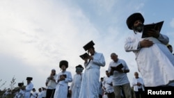 FILE - Orthodox Jewish pilgrims pray on a bank of a lake near the tomb of Rabbi Nachman of Breslov during the celebration of the Rosh Hashanah holiday, the Jewish New Year, in Uman, Ukraine, Sept. 21, 2017.