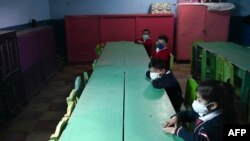 Los niños usan mascarillas como medida de precaución contra la propagación del nuevo coronavirus, mientras asisten a la ceremonia de inicio de clases en la Escuela Ramona Gil, en Chimaltenango, a unos 60 km al oeste de Ciudad de Guatemala, el 22 de febrero de 2021. 