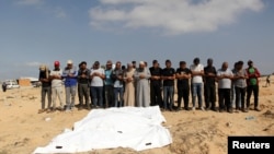 Los dolientes rezan junto a los cuerpos de los palestinos muertos en ataques israelíes debido a una operación militar israelí en Rafah, en medio del conflicto en curso entre Israel y Hamás, en Khan Younis, en el sur de la Franja de Gaza, el 19 de junio de 2024.