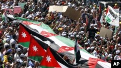 The Muslim Brotherhood's Islamic Action Front supporters carry banners and a large Jordanian flag at the biggest protest in the kingdom since late 2010, in Amman, Jordan, Friday, Oct. 5, 2012. (AP)