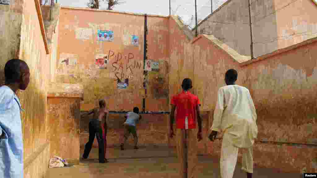 A youth watches a game of Eton Fives on a court styled based on an English public school's chapel, at a park in Katsina.