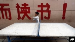 A child walks past large Chinese characters which partly reads "Study!" at the New Century Experimental School in Qikeshu village on the outskirts of Beijing (File Photo)