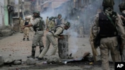 Pasukan pemerintah India menyingkirkan barikade jalan yang diletakkan para pengunjuk rasa selama bentrok setelah jam malam ditiadakan di beberapa bagian Srinagar wilayah Kashmir yang berada di bawah kontrol India (29/8). Srinagar, Kashmir. (foto: AP Photo/Mukhtar Khan)