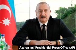 In this photo provided by Azerbaijan's Presidential Press Office, Azerbaijani President Ilham Aliyev holds a meeting in Baku, Dec. 25, 2024 following an Azerbaijan Airlines Embraer 190 plane crash.