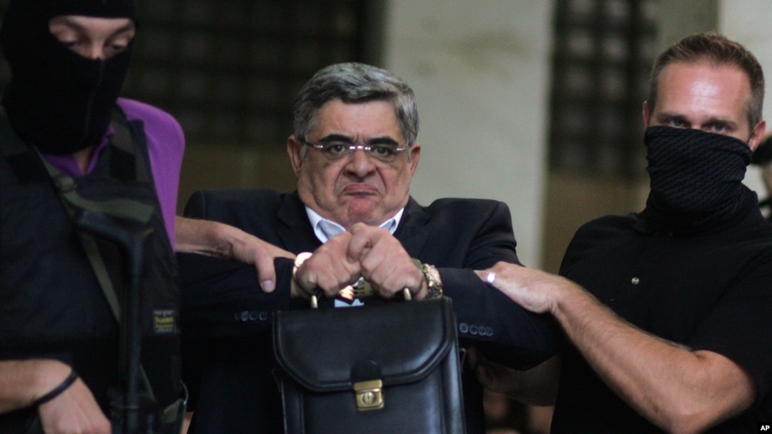 Ketua partai ekstremis sayap kanan Golden Dawn, Nikos Michaloliakos dikawal polisi anti-teror Yunani (28/9).