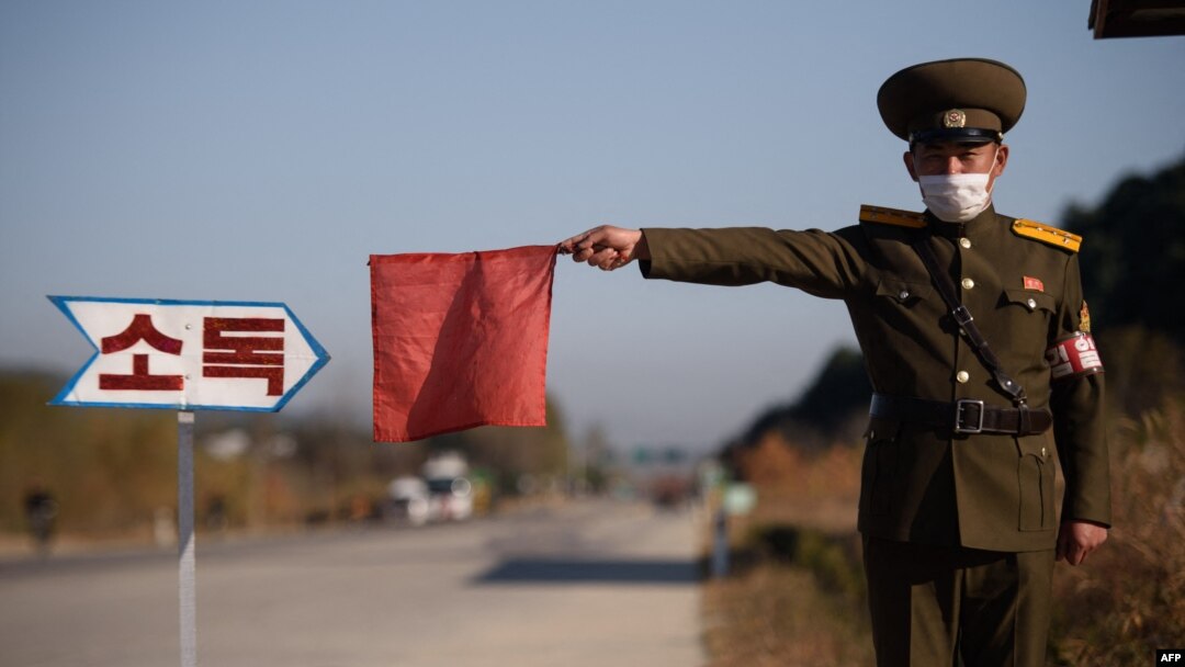 Arhiva - Pripadnik sjevernokorejske javne bezbjednosti zaustavlja taksi radi dezinfekcije, u sklopu napora protiv širenja Covida-19, na putu na ulazu u Vosan, pokrajina Kangvon, Sjeverna Koreja, 29. oktobra 2020