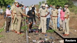 Petugas polisi memeriksa jalur kereta api setelah kereta menabrak pekerja migran yang tidur di lintasan di distrik Aurangabad di negara bagian barat Maharashtra, India, 8 Mei 2020. (Foto: Reuters)