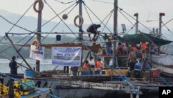 In this photo provided by Atin-Ito/Akbayan Party, activists and volunteers on fishing boats prepare for their journey at Masinloc, Zambales province, northwestern Philippines on May 15, 2024.