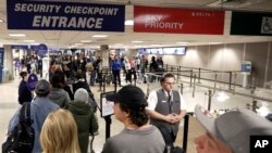 FILE - Travelers walk through a security checkpoint in Terminal 2 at Salt Lake City International Airport, Utah, Nov. 27, 2019.