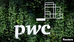 FILE - The logo of accounting firm PricewaterhouseCoopers (PwC) is seen on a board at the St. Petersburg International Economic Forum, Russia, June 6, 2019.
