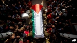 Members of the Palestinian national security forces carry the body of Palestinian Cabinet member Ziad Abu Ain during his funeral in the West Bank city of Ramallah, Dec. 11, 2014. 