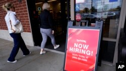 Un cartel de oferta de empleo es mostrado en el exterior de una tienda minorista en Vernon Hills, Illinois, EEUU, el 12 de junio de 2023.