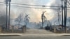 This photo provided by EJ Soto shows the destroyed entrance to the housing development from which her family was forced to evacuate due to wildfire, Wednesday, Jan. 8, 2024, in Altadena, Cali. (EJ Soto via AP)