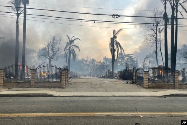 This photo provided by EJ Soto shows the destroyed entrance to the housing development from which her family was forced to evacuate due to wildfire on Jan. 8, 2025, in Altadena, California. (EJ Soto via AP)