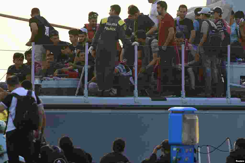 Migrants are seen onboard an Italian Coast Guard vessel following a rescue operation at the port on the Greek island of Kos, Aug. 16, 2015. 