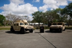 Vehicles are parked in front of where the National Guard is preparing for drive-through COVID-19 testing at C.B. Smith Park, March 19, 2020, in Pembroke Pines, Fla.