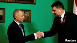 FILE - Latvia's President Raimonds Vejonis (R) shakes hands with his nominated Prime Minister Janis Bordans of New Conservative Party in Riga, Latvia, Nov. 7, 2018. On Wednesday, Bordans abandoned efforts to form a government.