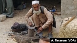 An old man in the bazaar in Lataband Tangi village, Afghanistan, smiled as he looked up from his work. 