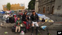 La familia Aguilar Bastida, procedente de Venezuela, fuera de la iglesia de la Santa Cruz y La Soledad, en donde algunos migrantes acampan, el martes 26 de diciembre de 2023, en Ciudad de México.