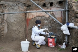 Seorang arkeolog berusaha merestorasi artefak di kota Pompeii, Italia selatan (foto: dok).