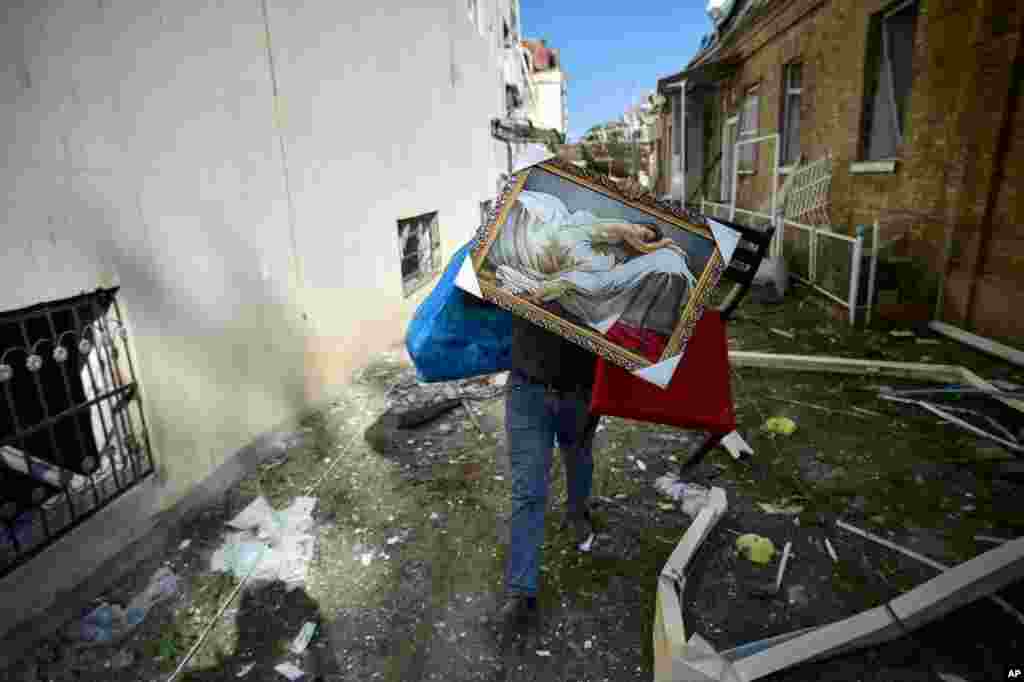 A man carries belongings from his damaged house two days after shelling by Armenian&#39;s artillery during fighting over the separatist region of Nagorno-Karabakh, in Ganja, Azerbaijan.