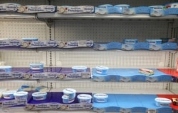 FILE - Picked-over shelves are seen at a supermarket during a countrywide lockdown to prevent the spread of COVID-19 in Zalka, Lebanon, April 7, 2020.