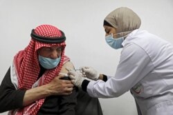 An elderly Palestinian man receives a shot of the COVID-19 coronavirus vaccine in the West Bank city of Nablus on March 22, 2021.