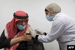 An elderly Palestinian man receives a shot of the COVID-19 coronavirus vaccine in the West Bank city of Nablus on March 22, 2021.