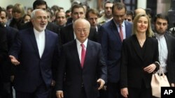 Iranian Foreign Minister Mohammad Javad Zarif, left, Director General of the International Atomic Energy Agency, IAEA, Yukiya Amano of Japan and European Union High Representative Federica Mogherini, right, arrive at the International Atomic Energy Agency