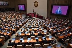 FILE - South Korea's President Moon Jae-in (center L) delivers a speech during the opening ceremony of the 21st National Assembly term in Seoul on July 16, 2020.