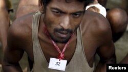 An identity number tag is seen on the neck of a migrant, who was found at sea on a boat, near Kanyin Chaung jetty after landing outside Maungdaw township, northern Rakhine state, Myanmar, June 3, 2015. 