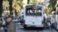 FILE - A man walks past the bus that exploded Tuesday in Tunis.