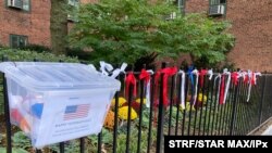 روبان‌هایی با رنگ‌های پرچم آمریکا که در آستانه روز ملی ‌کهنه‌سربازان در شهرکی در نیویورک آویخته شده‌اند - ۵ نوامبر ۲۰۲۰