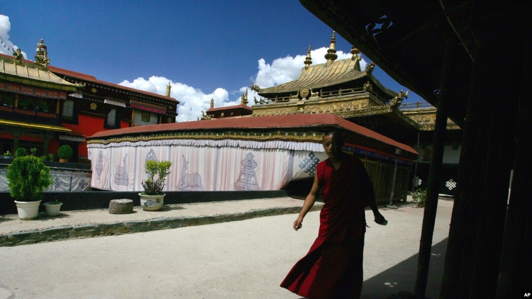 FILE - A Tibetan monk walks along the halls of the Jokhang Buddhist temple in Lhasa, Tibet.