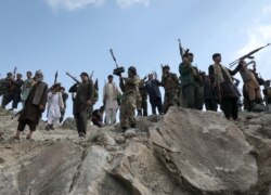 FILE - Armed men attend a gathering to announce their support for Afghan security forces and their willingness to fight against the Taliban, on the outskirts of Kabul, Afghanistan, June 23, 2021.
