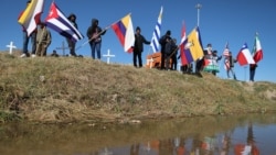 ARCHIVO - Migrantes que buscan asilo en Estados Unidos ondean banderas durante una misa binacional para recordar a los migrantes que han muerto intentando llegar a ese país en las orillas del Río Grande en Ciudad Juárez, estado de Chihuahua, México, el 9 de noviembre de 2024.