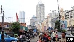 Pengendara motor di Jakarta di tengah pemandangan yang kontras gedung-gedung bertingkat, 8 April 2009.