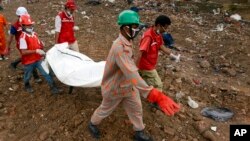 Regu penyelamat mengangkat jenazah korban dari reruntuhan gedung di Savar, Bangladesh (7/5). 