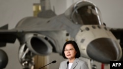 Presiden Taiwan Tsai Ing-wen (tengah) berbicara di depan jet tempur pertahanan (IDF) F-CK-1 yang diproduksi di dalam negeri selama kunjungannya ke Pangkalan Angkatan Udara Penghu di Pulau Magong di Kepulauan Penghu pada 22 September 2020. (Foto: AFP)